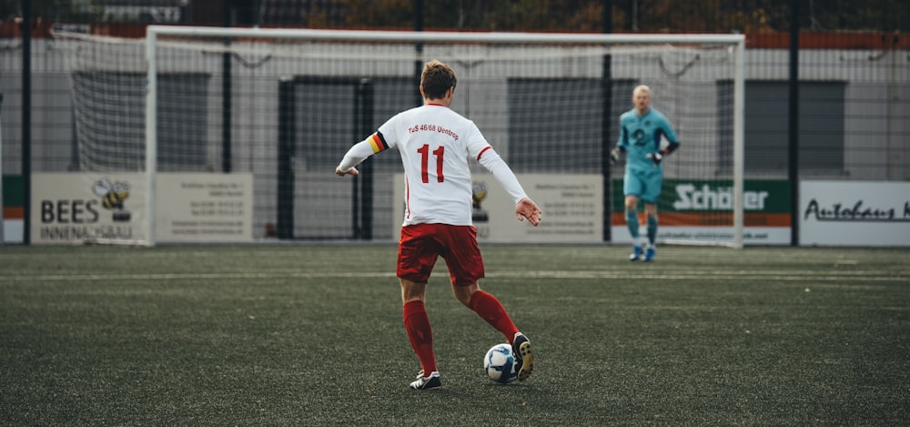 a man kicking a soccer ball on a field