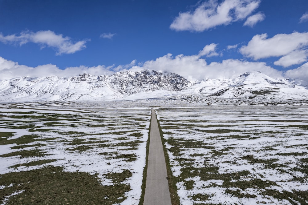 Eine lange Straße mitten auf einem verschneiten Feld