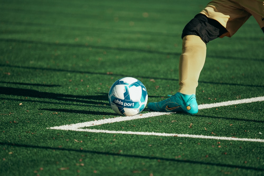 a soccer ball on a soccer field with a person's feet