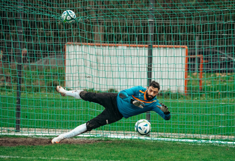 a man diving for a soccer ball on a field
