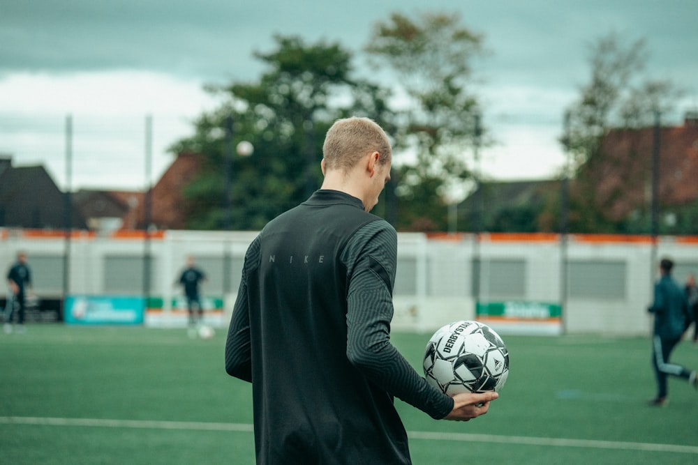 a man holding a soccer ball on a field