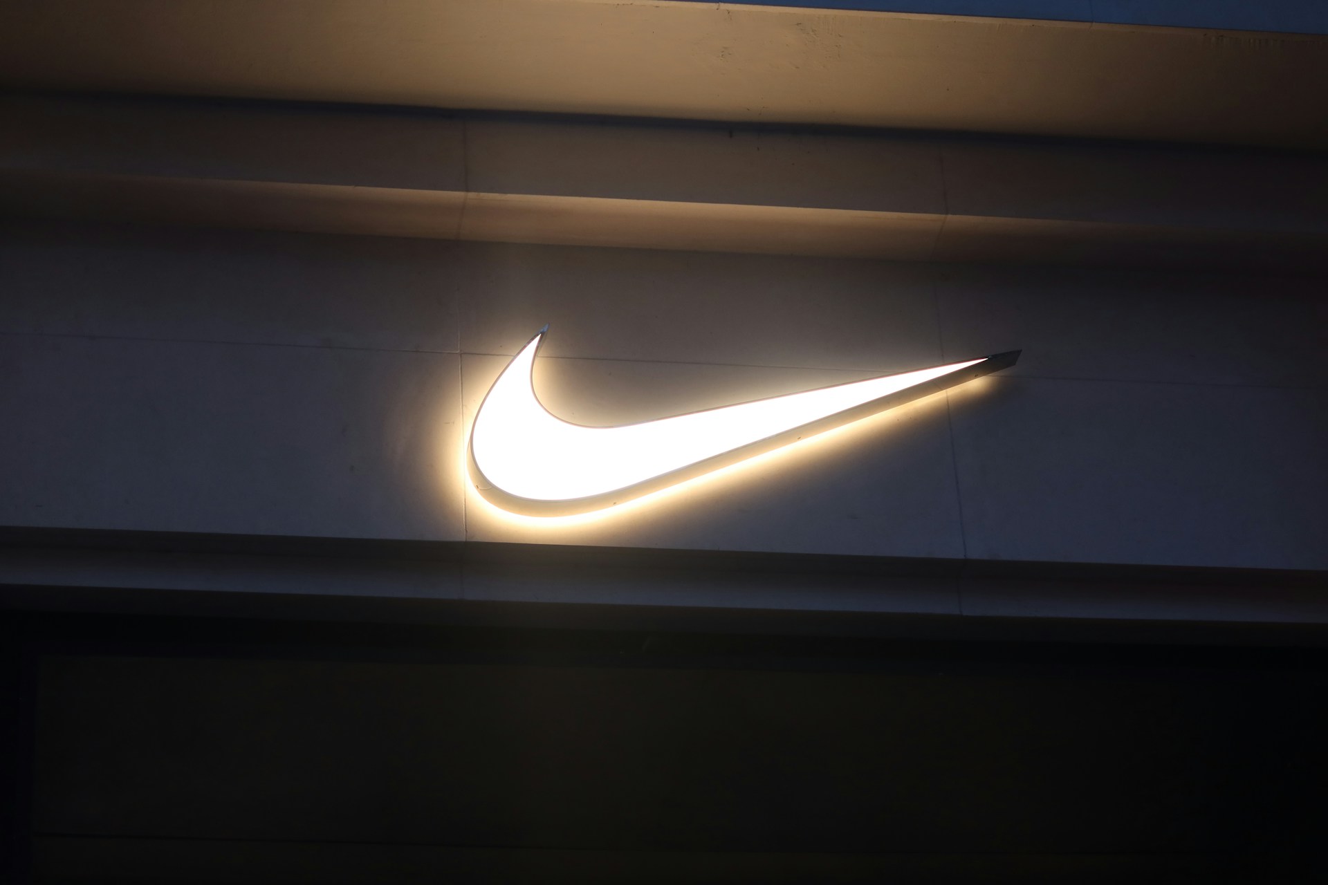 a nike logo is lit up on a wall