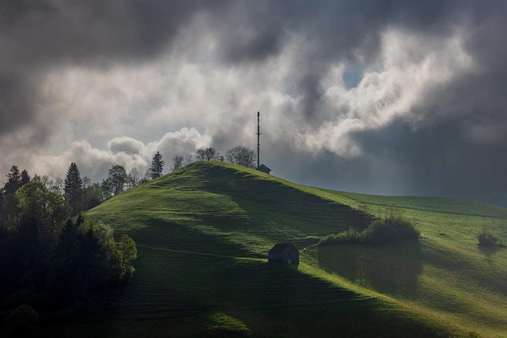 a grassy hill with a cross on top of it