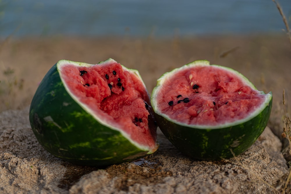 a couple of pieces of watermelon sitting on top of a rock