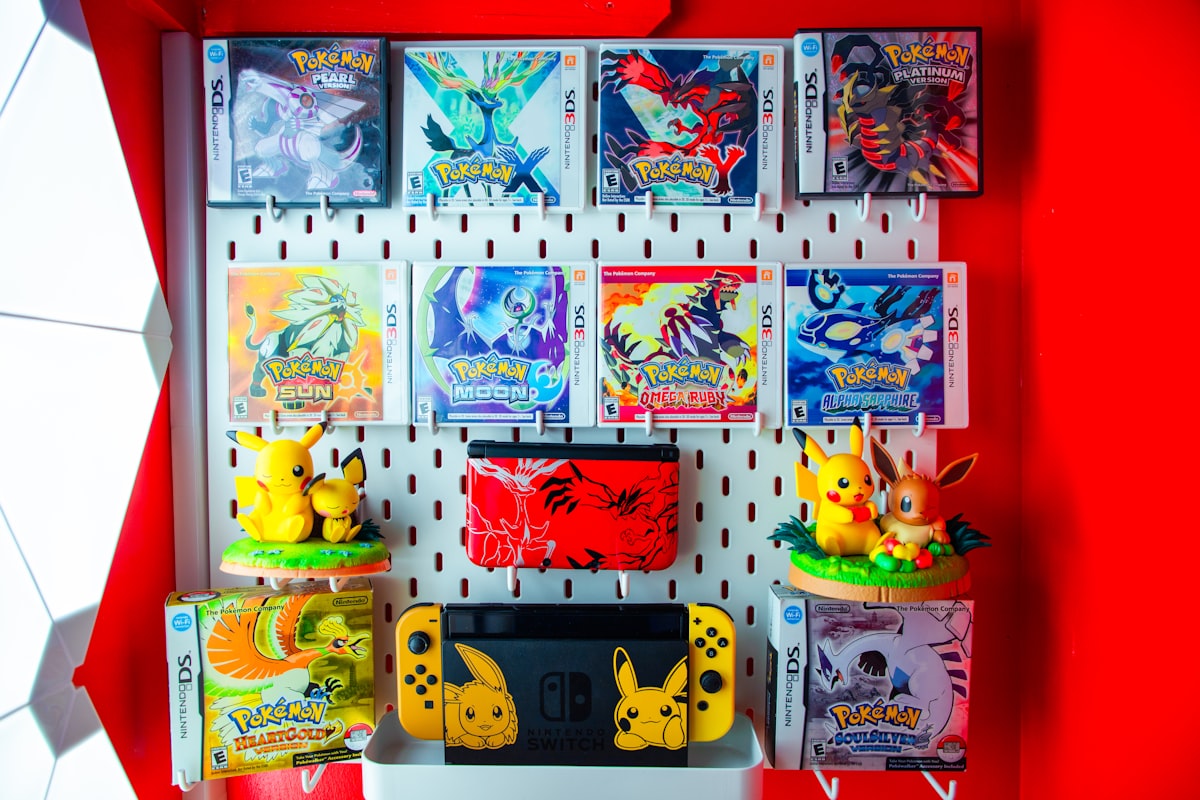 Pokemon trading cards and figurines arranged in a home collector display shelf with figures and binders