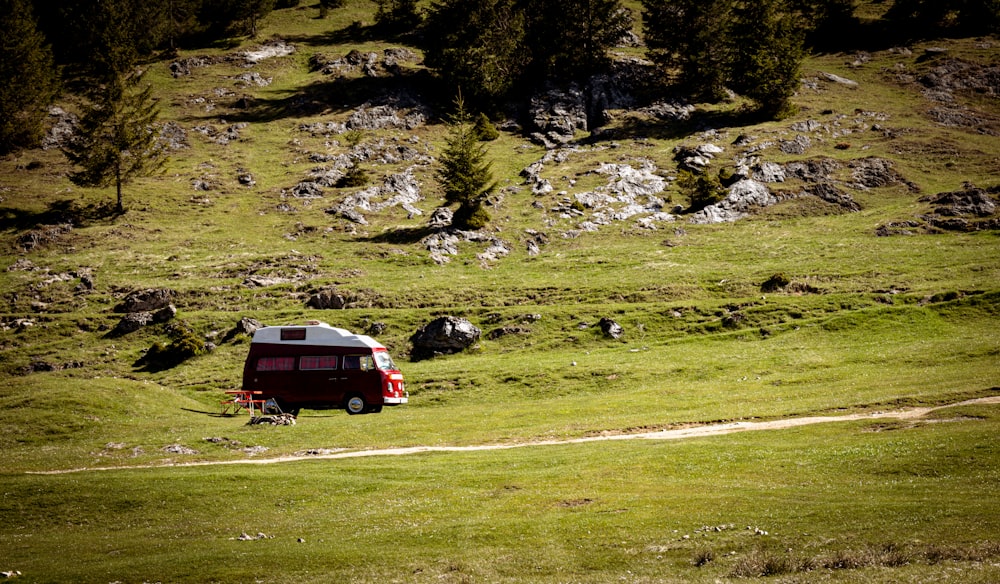 a van is parked on the side of a grassy hill
