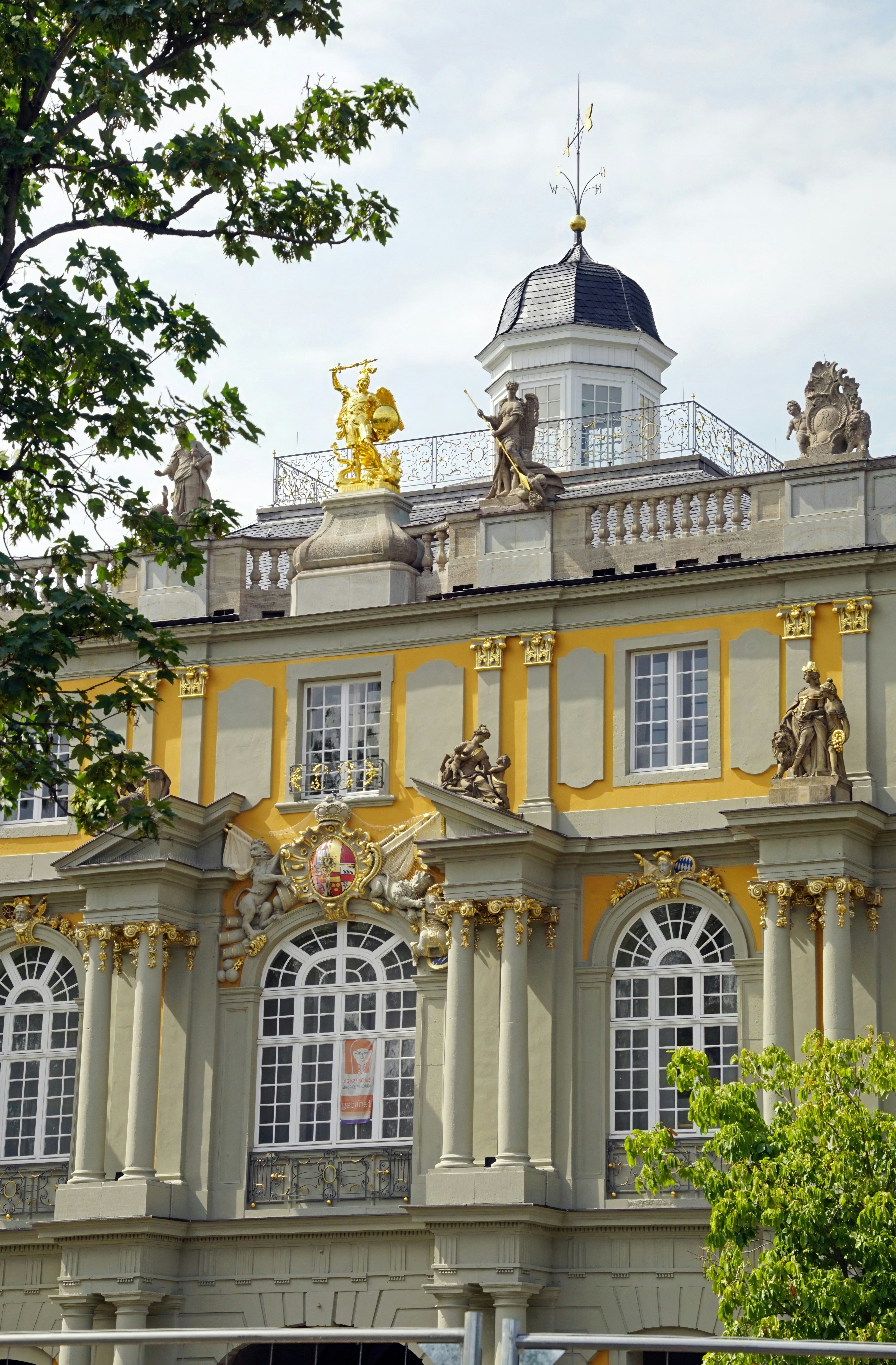 Un grande edificio con molte finestre e statue in cima