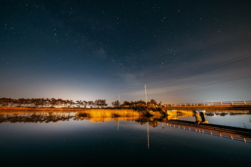 a body of water with a bridge in the background