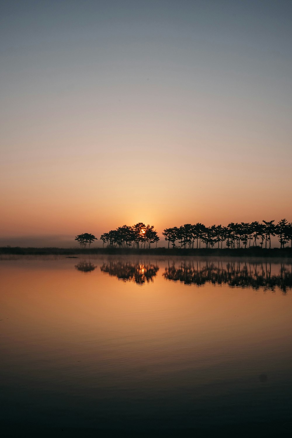 the sun is setting over a body of water