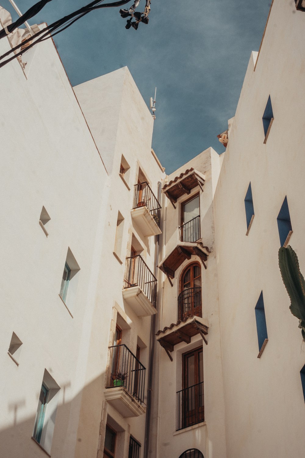 a tall white building with balconies and windows