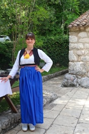 a woman wearing a blue skirt and a white shirt