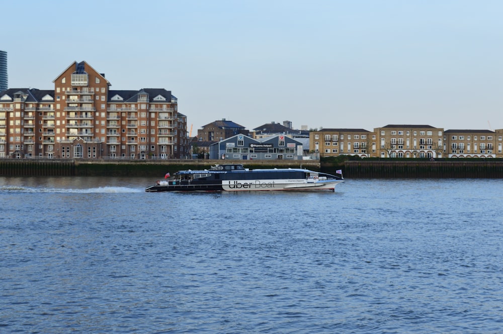 a boat traveling down a river next to tall buildings