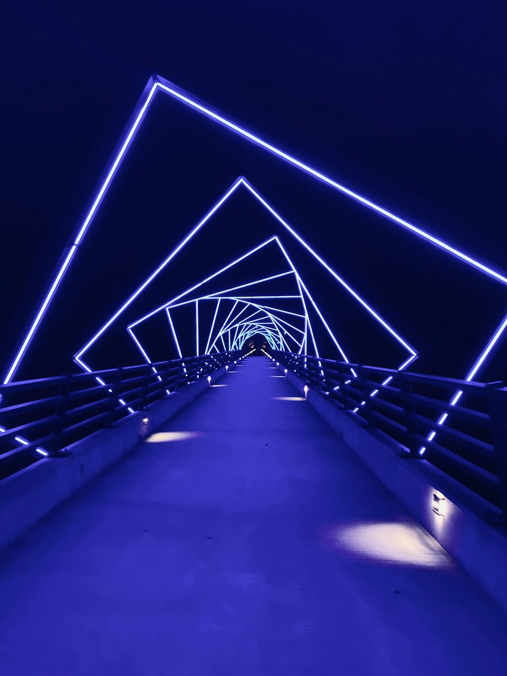 a walkway with blue lights going through it
