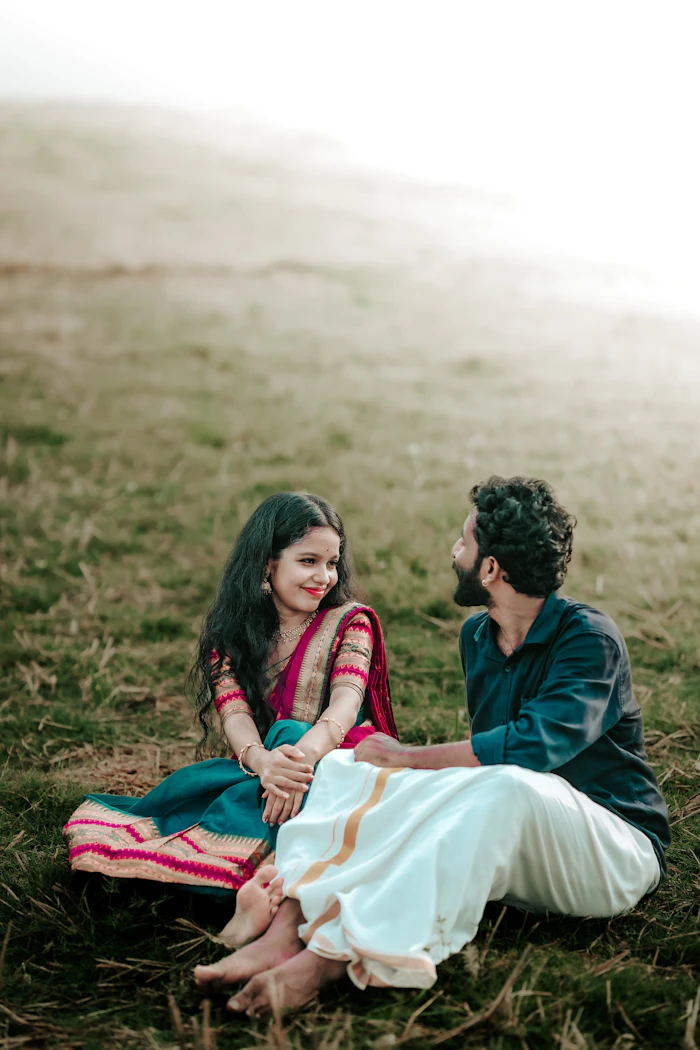 Priya and Arjun sitting on the grass, smiling at each other