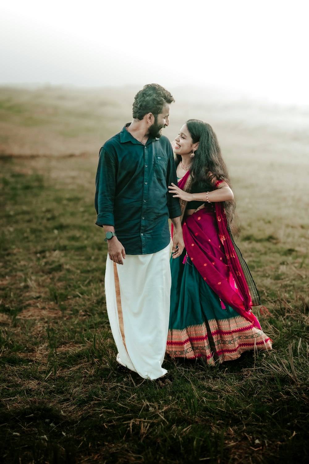 a man and a woman standing in a field