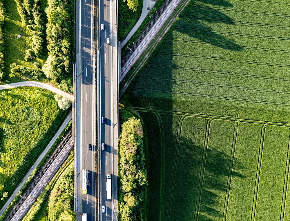 an aerial view of a highway in the middle of a green field