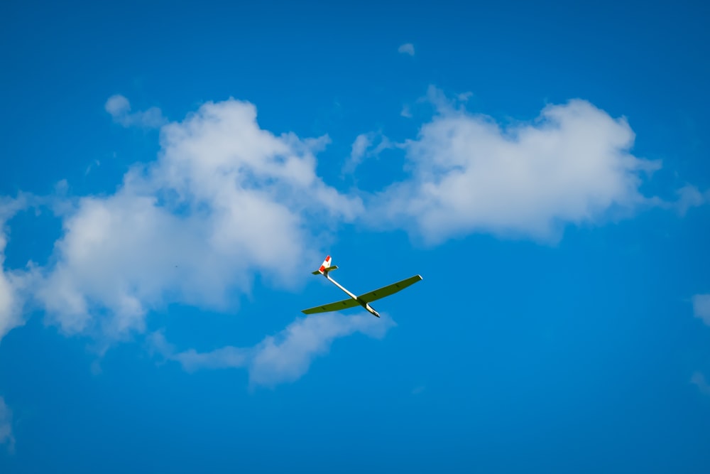 a single engine plane flying through a blue sky