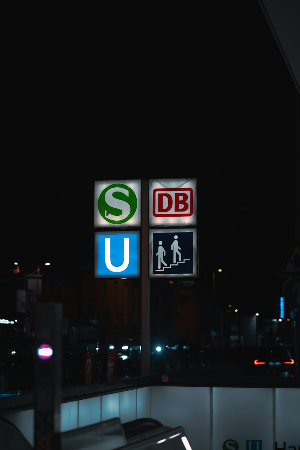 a parking lot at night with a lighted sign