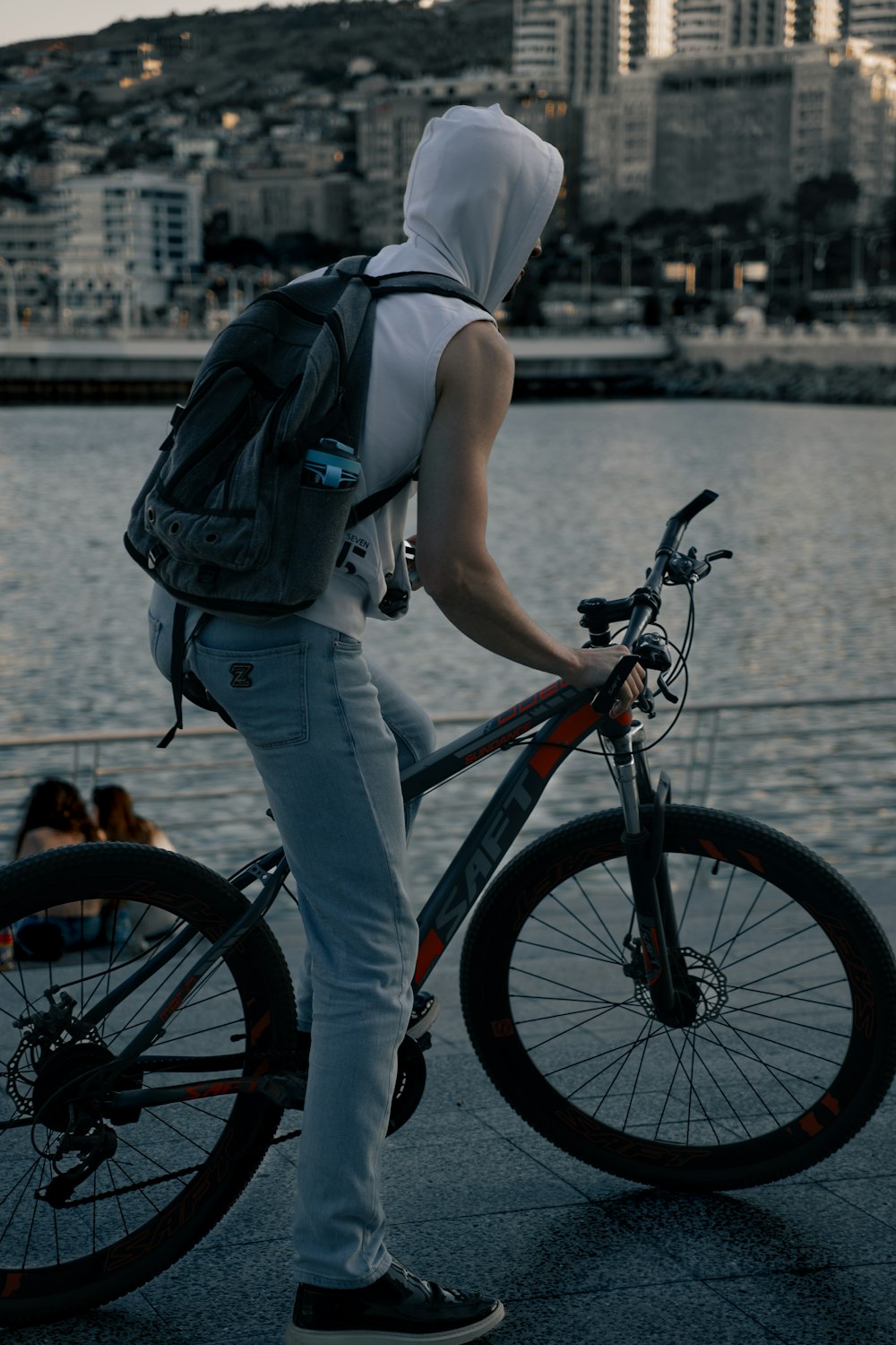 a person in a hoodie is standing next to a bike