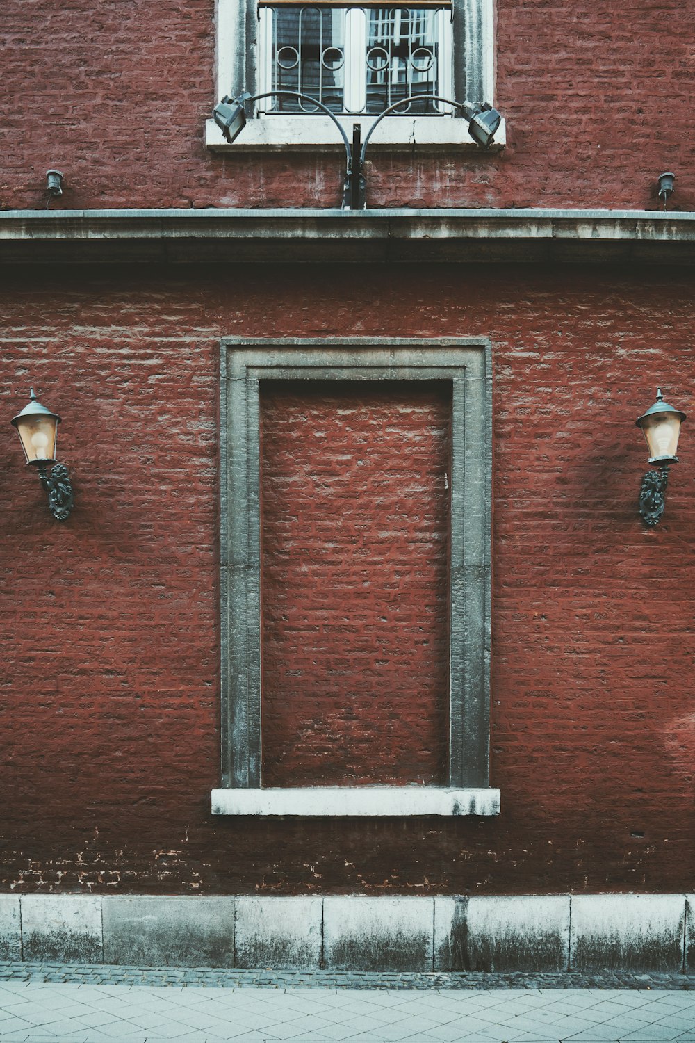 a red brick building with a window and two street lights