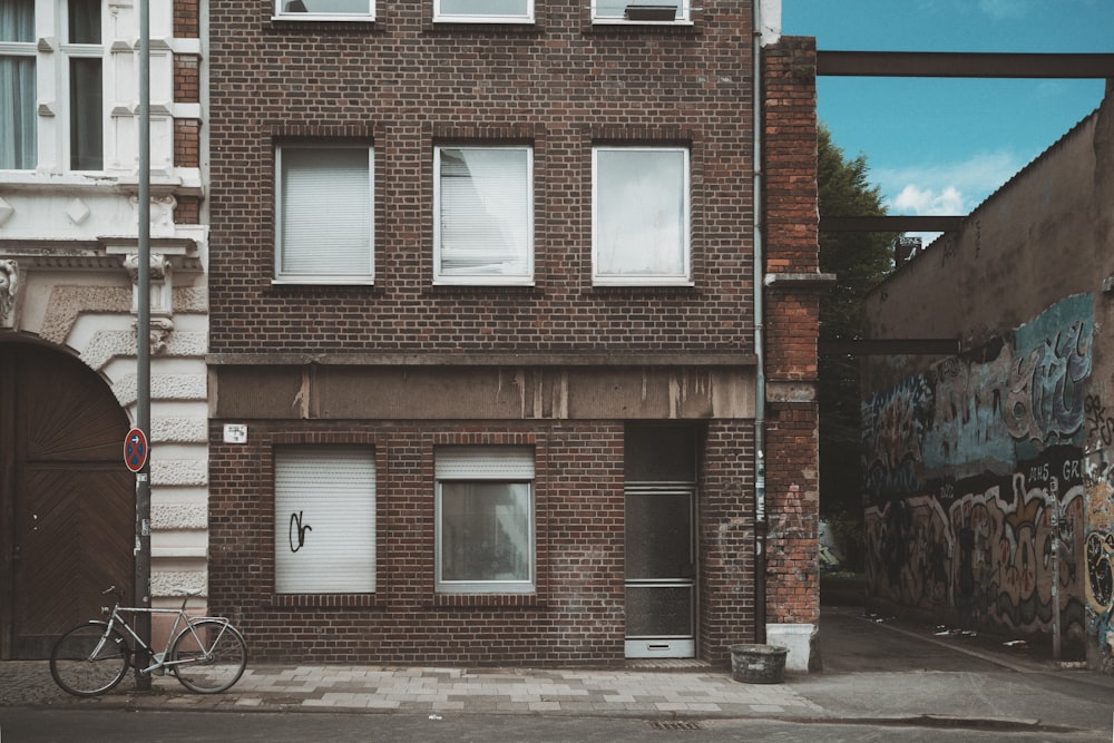 a bicycle parked in front of a brick building