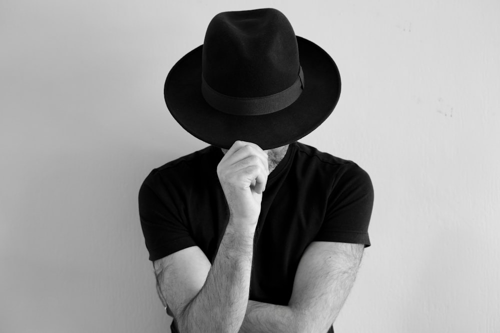 a man with a hat covering his face