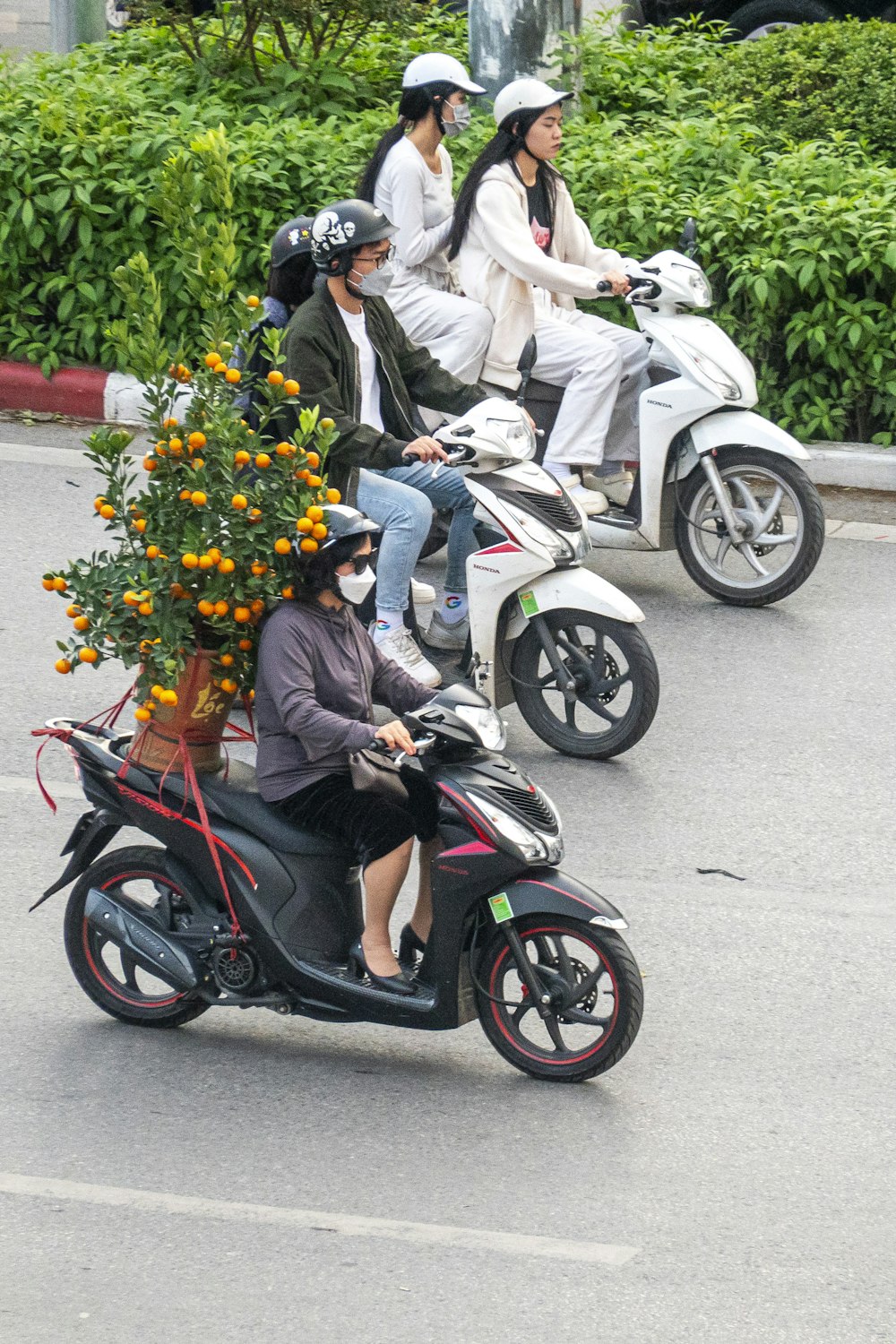 a group of people riding scooters down a street