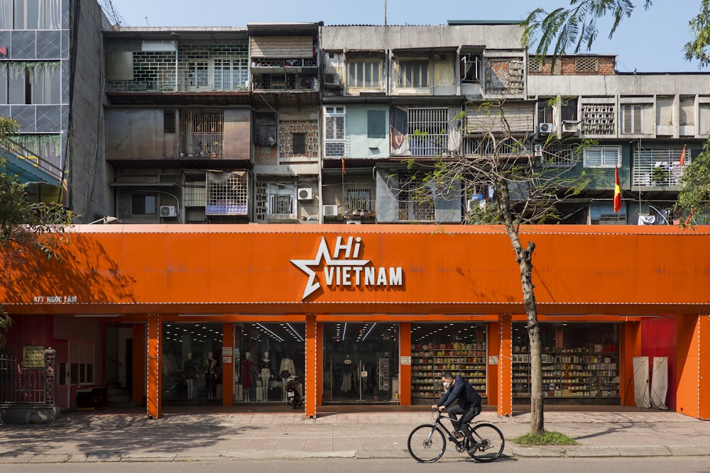 a person riding a bike in front of a building