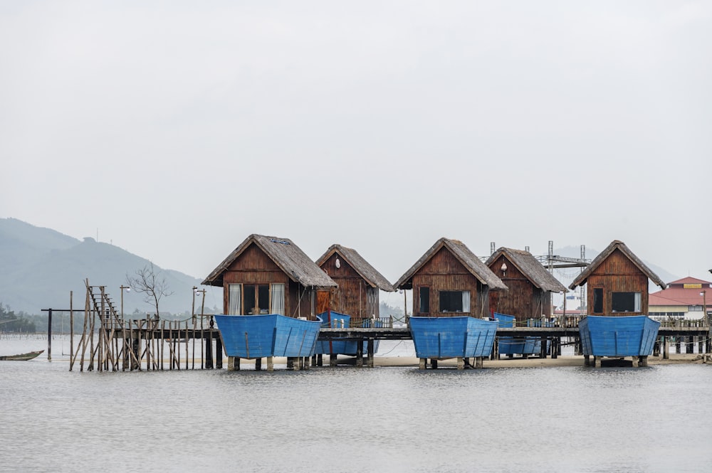 a row of beach huts sitting on top of a body of water