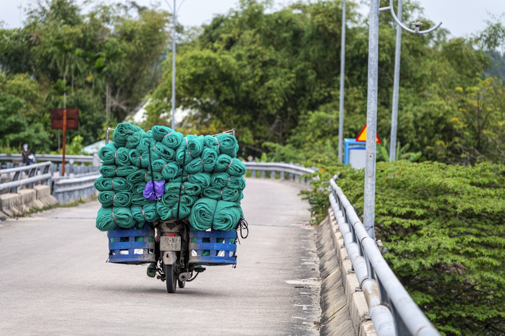 a person on a motorcycle with a cart of blankets on the back of it