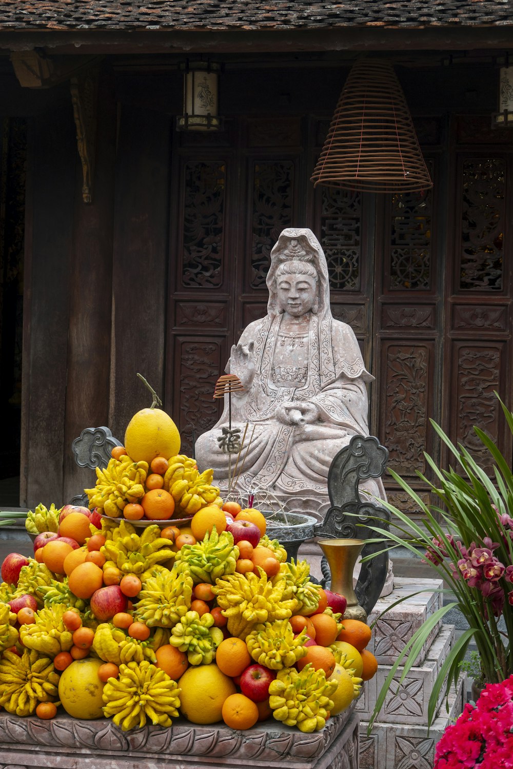 a pile of fruit sitting next to a statue