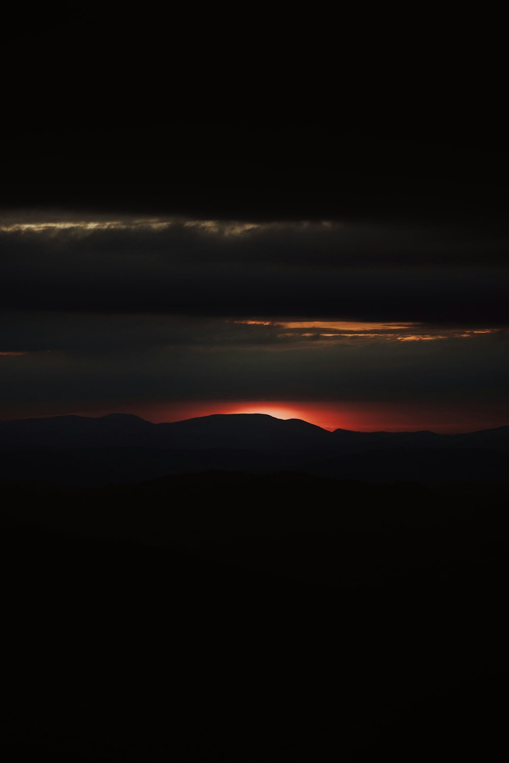 the sun is setting over a mountain range