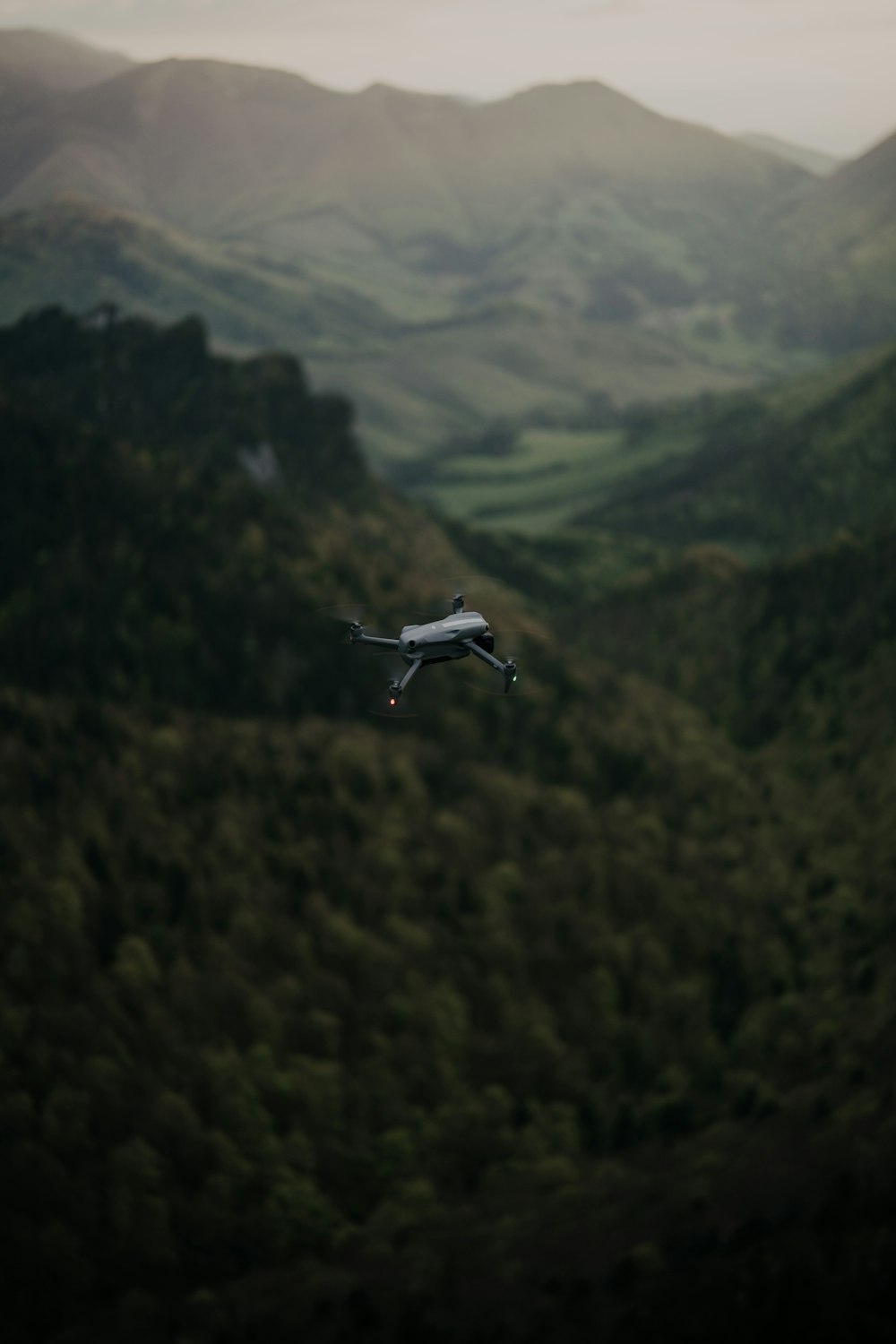a small airplane flying over a lush green hillside