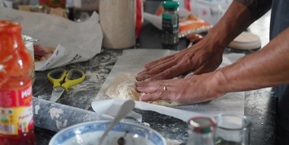 a person is kneading dough on a counter