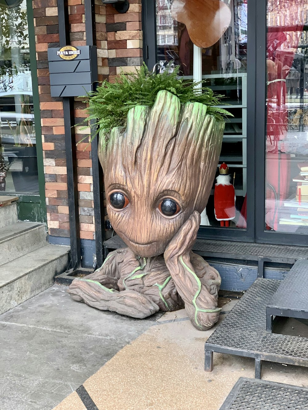 Eine Statue eines Baby-Groote steht vor einem Geschäft