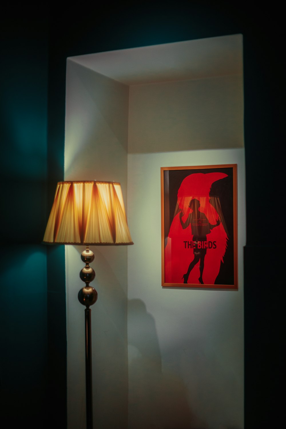 a room with a lamp and a picture on the wall