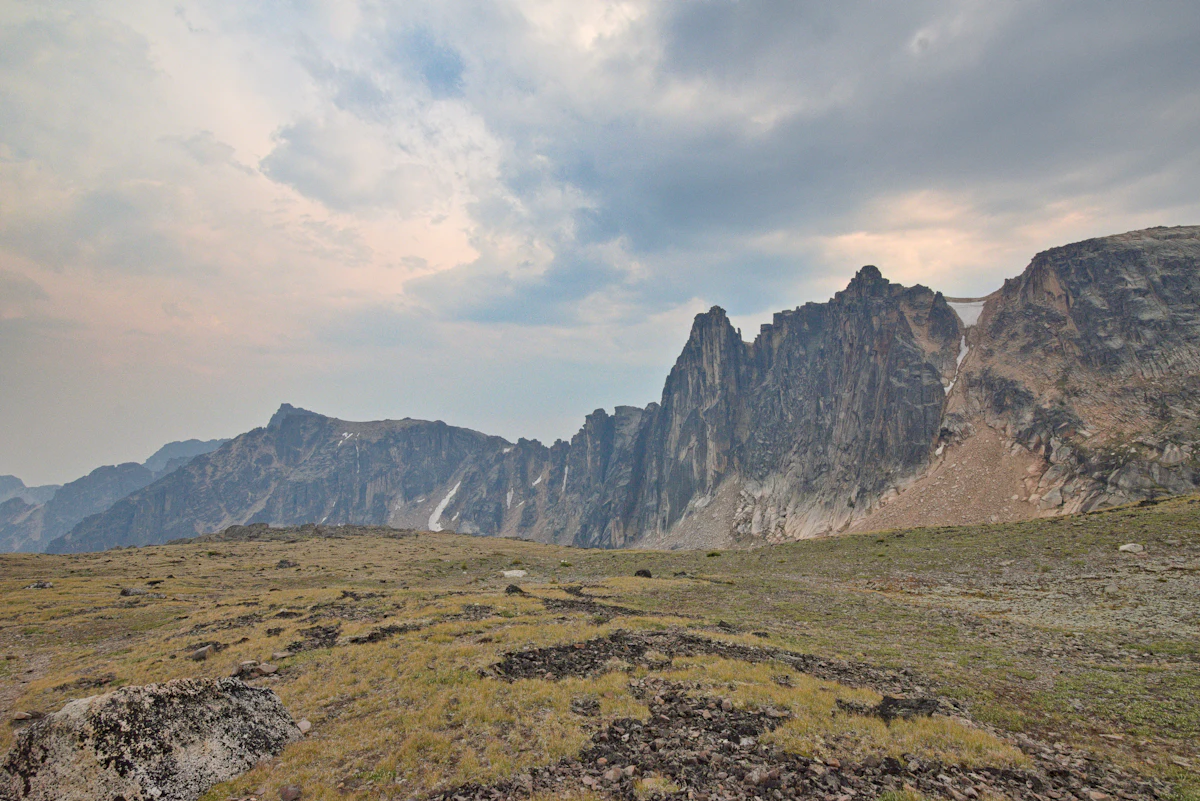 Dark crags rising above rocky alpine tundra in Cathedral Provincial Park