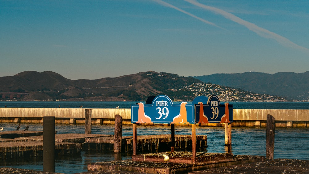 there are two blue and red signs on a pier