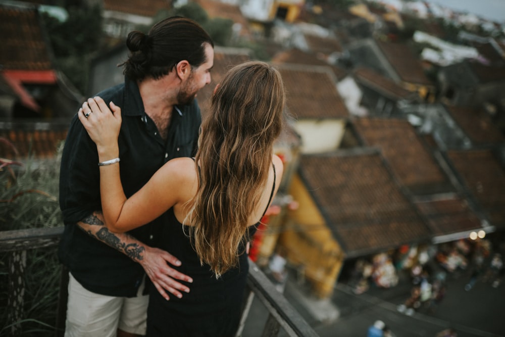 a man and a woman kissing on a balcony