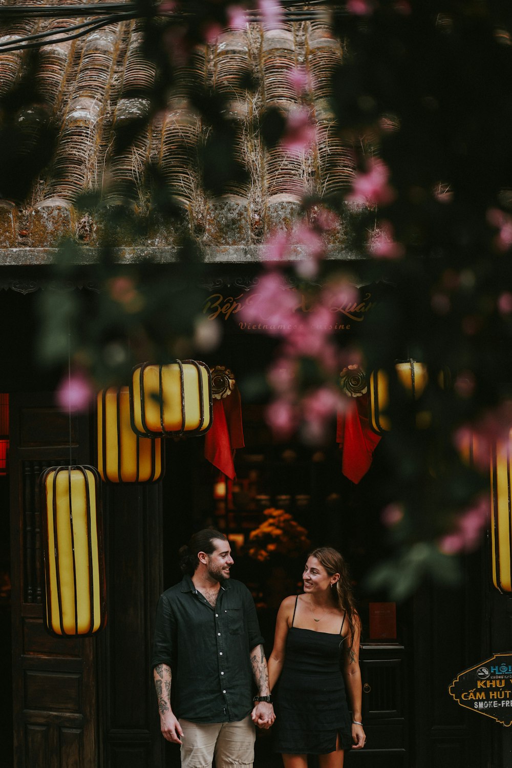 a man and a woman standing in front of a building