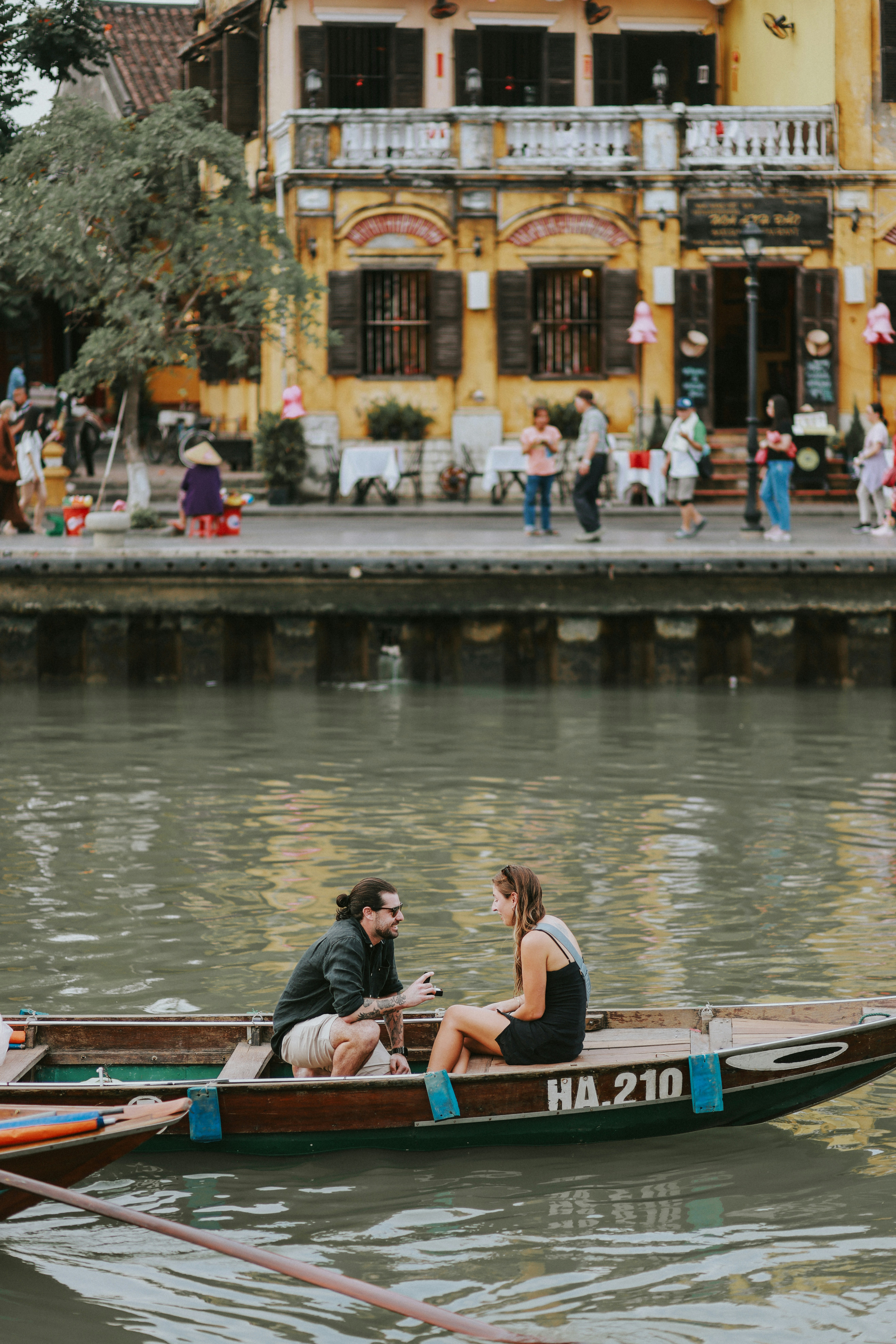 A man and a woman sitting in a small boat photo – Free Woman Image on ...