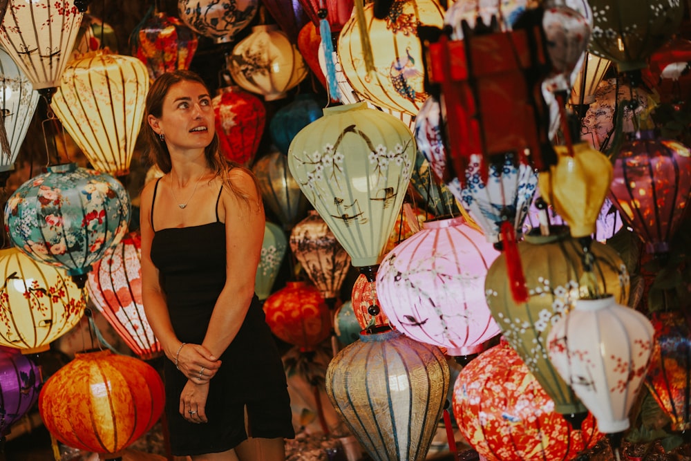 a woman standing in front of a display of lanterns