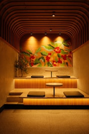 a dimly lit room with benches and a painting on the wall
