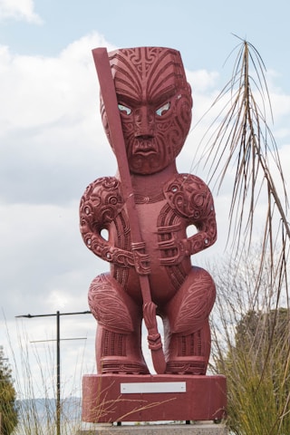 a statue of a MĀORI man holding a sword
