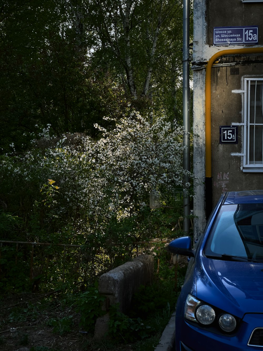 a blue car parked in front of a house
