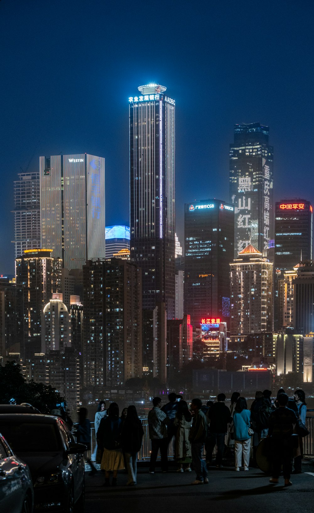 a group of people standing in front of a city at night