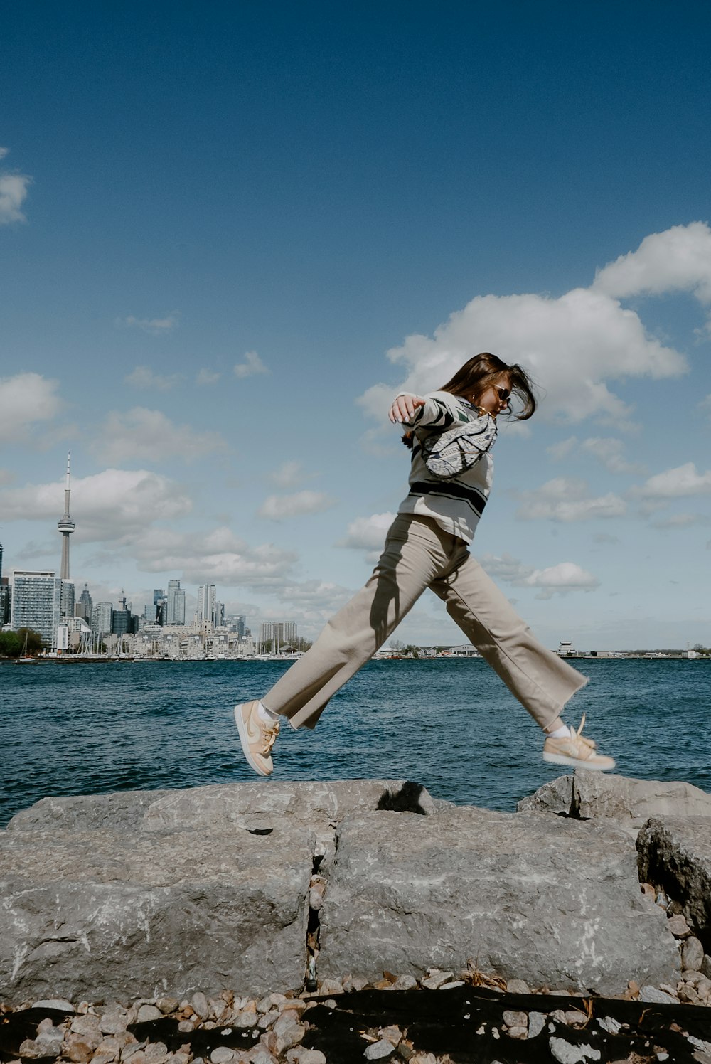 a woman jumping off a rock into the air