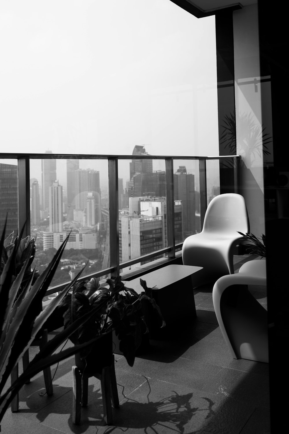 a black and white photo of a balcony overlooking a city