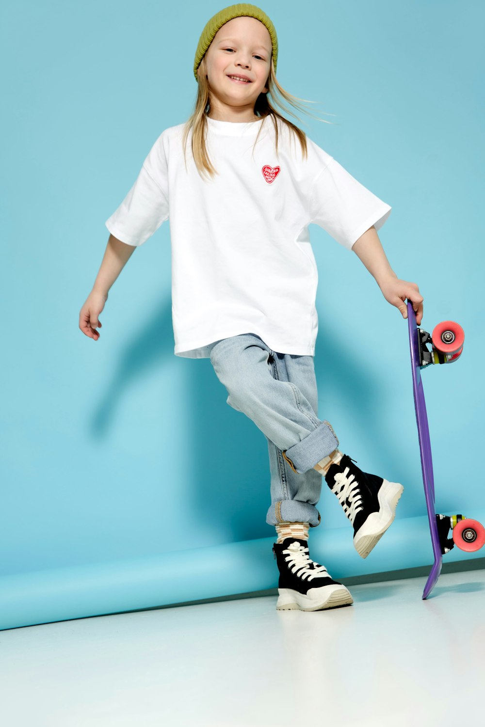 a young girl is posing with her skateboard