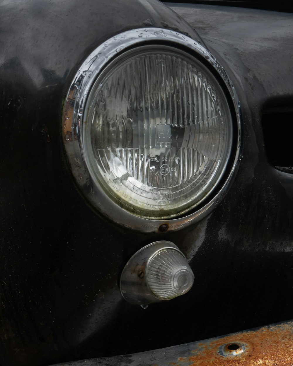 un gros plan d’un phare sur une vieille voiture